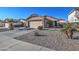 Charming single-story home with a well-manicured gravel yard, palm trees, and a two-car garage at 214 N 222Nd Dr, Buckeye, AZ 85326