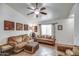 Comfortable living room with large window, ceiling fan, and warm, inviting decor at 214 N 222Nd Dr, Buckeye, AZ 85326