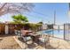 Outdoor dining set next to pool with clear blue skies and an inviting atmosphere at 2143 W Eugie Ave, Phoenix, AZ 85029