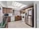 Well-lit kitchen with modern stainless steel refrigerator and wood cabinetry at 2143 W Eugie Ave, Phoenix, AZ 85029