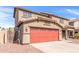 Two-story home featuring a red two-car garage with a driveway, a tile roof, and a low-maintenance desert landscape at 2190 W San Tan Hills Dr, San Tan Valley, AZ 85144