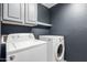 Functional laundry room with modern washer and dryer, complemented by stylish gray cabinets at 2190 W San Tan Hills Dr, San Tan Valley, AZ 85144