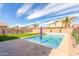 Backyard features a sparkling pool, an umbrella, turf and brick pavers at 2190 W San Tan Hills Dr, San Tan Valley, AZ 85144