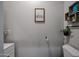 Modern half bathroom featuring a toilet, sink, and decorative elements on a gray painted wall at 2246 E Sheridan St, Phoenix, AZ 85006