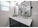 Modern bathroom featuring a dual sink vanity with marble countertop, sleek mirrors, and a tiled shower at 2246 E Sheridan St, Phoenix, AZ 85006