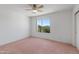 Bedroom featuring neutral walls, ceiling fan and a window looking out onto the landscaped yard at 26234 N 46Th St, Phoenix, AZ 85050