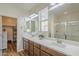 Well-lit bathroom with dual sinks, large mirrors, and glass enclosed shower at 2673 S Balsam Dr, Gilbert, AZ 85295