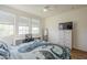 Bright bedroom with large windows, desk, and dresser, illuminated by a modern ceiling fan at 2673 S Balsam Dr, Gilbert, AZ 85295