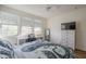 Bright bedroom with large windows, desk, and dresser, illuminated by a modern ceiling fan at 2673 S Balsam Dr, Gilbert, AZ 85295