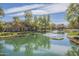 Scenic view of a community pond with fountains, mature trees, and walking paths at 2673 S Balsam Dr, Gilbert, AZ 85295