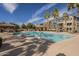 Large community swimming pool with clear water, palm trees, and lounge chairs for relaxation at 2673 S Balsam Dr, Gilbert, AZ 85295