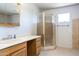 Bathroom featuring a single sink vanity, framed mirror, and enclosed shower with tan tile accents at 27141 E Javelina Dr, Florence, AZ 85132