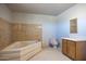 Bright bathroom featuring a soaking tub, toilet, and single sink vanity with wood cabinets at 27141 E Javelina Dr, Florence, AZ 85132