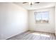 Bedroom with vinyl wood flooring, white walls, and a window overlooking an outdoor landscape at 27141 E Javelina Dr, Florence, AZ 85132