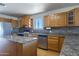 Bright kitchen with wood cabinets, stainless steel appliances, and tile backsplash at 27141 E Javelina Dr, Florence, AZ 85132