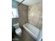 Bathroom features tiled walls, a toilet, bathtub and window at 2837 W Almeria Rd, Phoenix, AZ 85009