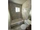 A tiled bathroom with a shower/tub, toilet, and a window for natural light at 2837 W Almeria Rd, Phoenix, AZ 85009