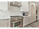 Close-up of a stainless steel range and vent hood, complemented by modern herringbone backsplash at 2861 E Camellia Dr, Gilbert, AZ 85296