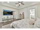 Bright main bedroom featuring a ceiling fan, TV, wood floors, and ensuite bathroom at 2861 E Camellia Dr, Gilbert, AZ 85296