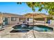 Inviting backyard pool with mature landscaping, string lights, and patio umbrella offering shady relaxation at 2861 E Camellia Dr, Gilbert, AZ 85296