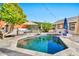 Backyard pool with lush greenery, outdoor seating, built-in grill, and blue umbrella at 2861 E Camellia Dr, Gilbert, AZ 85296