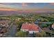 Beautiful aerial view of a home with tile roof near a golf course and scenic mountain backdrop at sunset at 28714 N Verde River Way, Rio Verde, AZ 85263