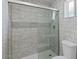 Modern bathroom featuring tiled shower with glass door and tiled walls at 3223 W Purdue Ave, Phoenix, AZ 85051