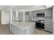 Contemporary kitchen showcasing a granite island, stainless steel appliances, and ample cabinet space at 3223 W Purdue Ave, Phoenix, AZ 85051