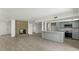 Open floor plan featuring brick fireplace, wood look tile flooring and gray cabinets at 3223 W Purdue Ave, Phoenix, AZ 85051