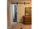 Bedroom featuring ensuite bathroom access via a sliding barn door and a wooden dresser at 3828 W Port Au Prince Ln, Phoenix, AZ 85053