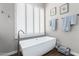 Bright bathroom features a soaking tub under plantation shutters and neutral wall decor for a serene ambiance at 42429 N Cross Timbers Ct, Anthem, AZ 85086