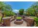 Beautiful backyard with a firepit, waterfall feature, artificial grass and palm trees at 4245 S 247Th Dr, Buckeye, AZ 85326