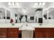 Elegant bathroom featuring double sinks with modern fixtures, wood cabinets, and a vanity area at 4245 S 247Th Dr, Buckeye, AZ 85326