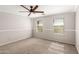 Bright bedroom featuring a ceiling fan, two windows, and neutral carpeting at 4245 S 247Th Dr, Buckeye, AZ 85326