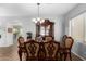 Elegant dining room with a chandelier, a dark wood table, and comfortable chairs at 4245 S 247Th Dr, Buckeye, AZ 85326