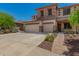 A two-story home showcasing a well-manicured yard and a stone-detailed facade, complemented by a blue sky at 4245 S 247Th Dr, Buckeye, AZ 85326