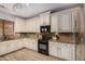 A well-lit kitchen featuring white cabinetry, granite countertops, and modern black appliances at 4245 S 247Th Dr, Buckeye, AZ 85326