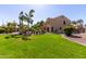 Expansive backyard with lush green grass, mature palm trees, and a view of the home's exterior at 4529 S Granite St, Gilbert, AZ 85297