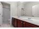 Bathroom with double sinks, dark wood cabinets, a large mirror, and a shower/tub with a shower curtain at 4529 S Granite St, Gilbert, AZ 85297