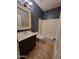 Cozy bathroom featuring a vanity, toilet, and bathtub with shower, all set against earth-tone tiling at 4529 S Granite St, Gilbert, AZ 85297