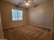 Carpeted bedroom with large window and neutral walls, and a ceiling fan at 4529 S Granite St, Gilbert, AZ 85297