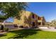 Exterior view of the home showcasing a spacious backyard with lush green grass, shed, and covered patio at 4529 S Granite St, Gilbert, AZ 85297