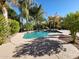 Beautiful backyard pool with mature landscaping and a rock waterfall feature at 4529 S Granite St, Gilbert, AZ 85297