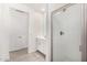 Bright bathroom featuring a modern glass-enclosed shower, white tiled floors, and a vanity with storage at 4642 W Suncup Dr, San Tan Valley, AZ 85144