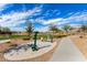 Outdoor community exercise area on concrete pad with walking path and lush landscaping at 4642 W Suncup Dr, San Tan Valley, AZ 85144