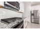 Close-up of the kitchen featuring a gas range, granite countertops, and stainless steel refrigerator at 4642 W Suncup Dr, San Tan Valley, AZ 85144