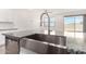 Kitchen island sink with granite countertop and stainless steel appliances overlooking outdoor slider at 4642 W Suncup Dr, San Tan Valley, AZ 85144