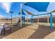 Community playground featuring a slide, swings, and shade canopies on a wood chip surface at 4642 W Suncup Dr, San Tan Valley, AZ 85144