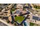 Aerial view of home highlighting solar panels, large backyard with putting green, patio, and green lawn at 4702 N 151St Dr, Goodyear, AZ 85395