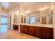 Well-lit bathroom featuring dual sinks, a large mirror, and ample counter space at 4702 N 151St Dr, Goodyear, AZ 85395